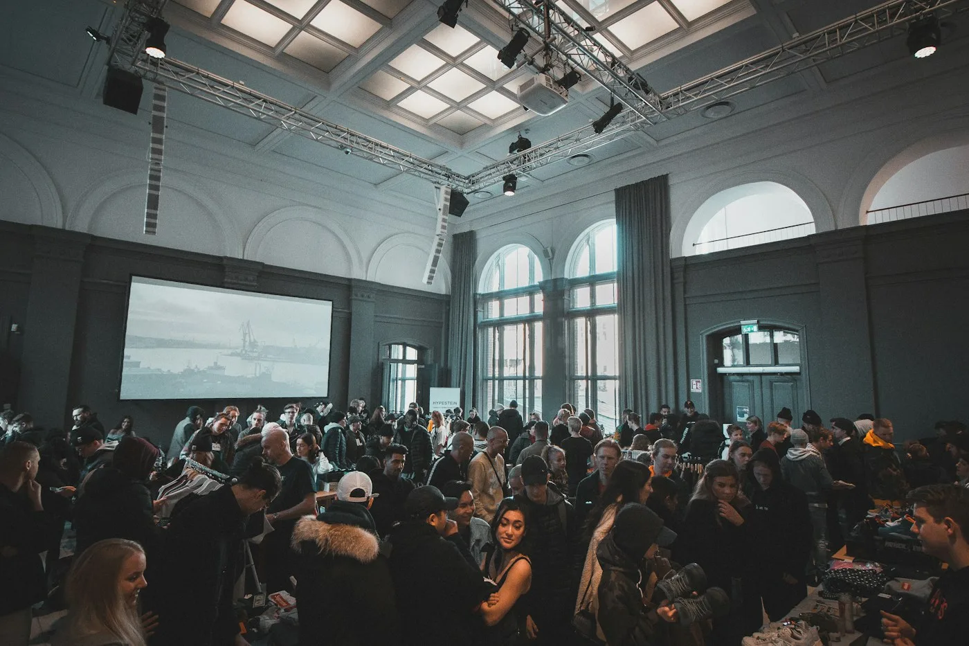 Conference attendees gathered around tables in a bright event hall